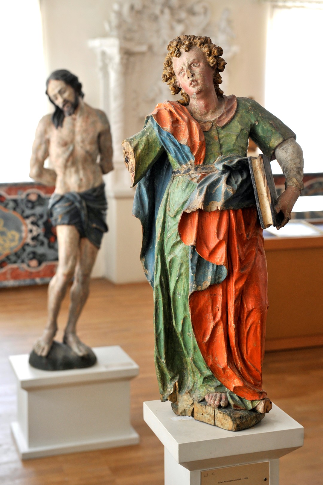 Bildnachweis:  Evangelist Johannes von Adam Krumpper (Foto: Emanuel Gronau) sowie Porträt von Georg Petel, dem berühmtesten Vertreter der „Weilheimer Schule“, Kopie nach einem Original vom flämischen Maler Antonys van Dyck, 1599 (Foto: Stadtmuseum Weilheim)