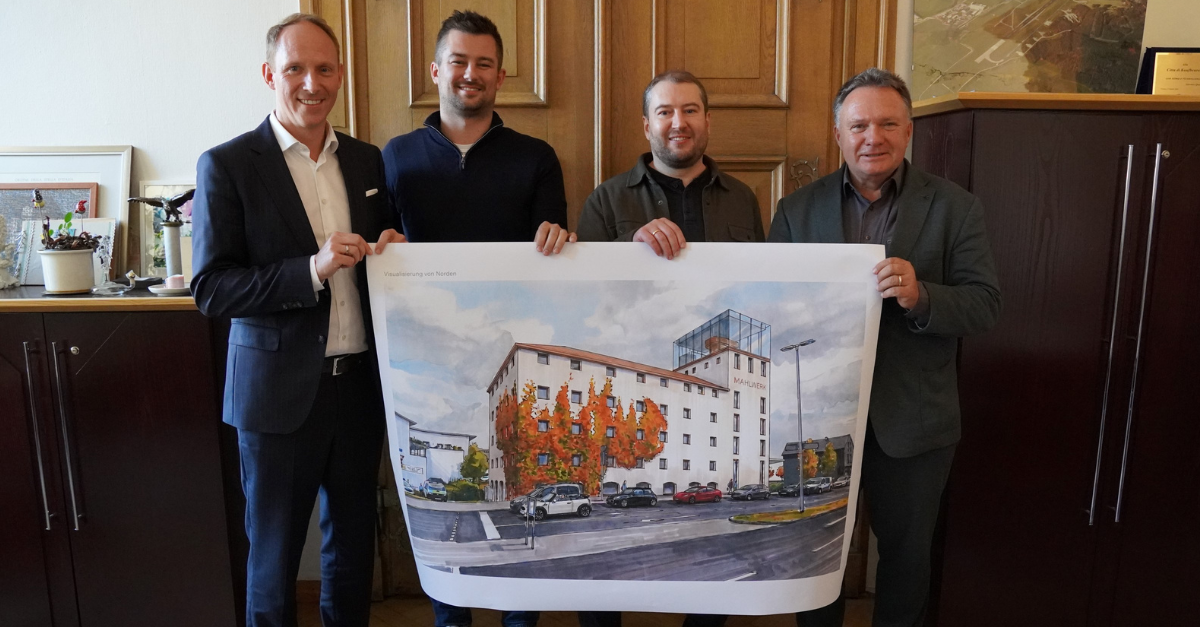 von links: Oberbürgermeister Stefan Bosse, die neuen Eigentümer Joshua Zappe und Alexander Braml und der Wirtschaftsreferent Andreas Bauer.
Auf dem Foto ist eine Visualisierung zu sehen. Es handelt sich um keine finalen Ausbaupläne

Foto: Tobias Müller/Stadt Kaufbeuren